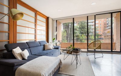 Stylish living room with contemporary furniture and large windows offering a cityscape view in Bogotá.
