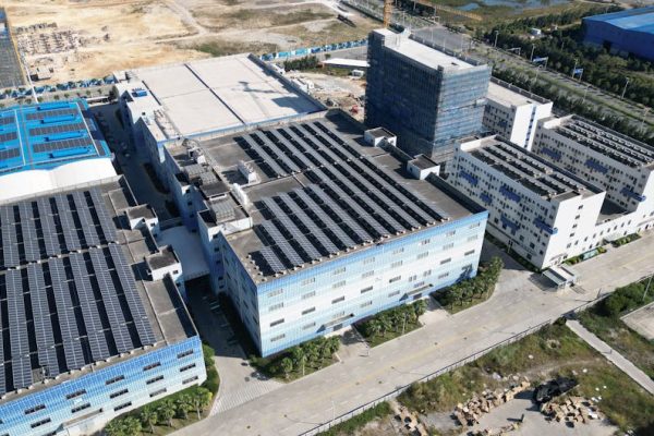 Industrial buildings with solar panels, aerial view showcasing renewable energy.