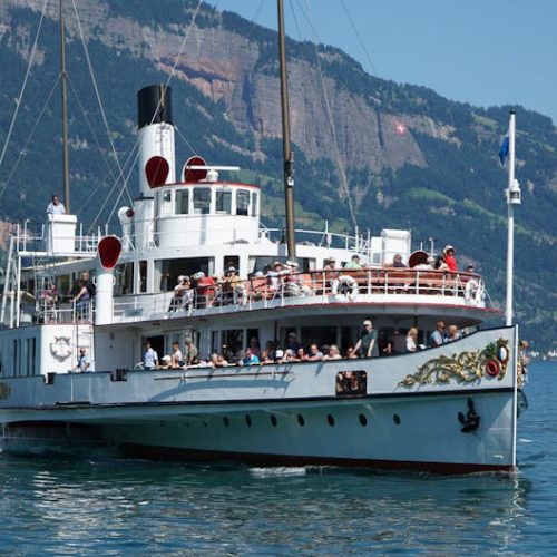 Explore a vintage steamboat on Lake Lucerne with breathtaking Swiss mountain views.